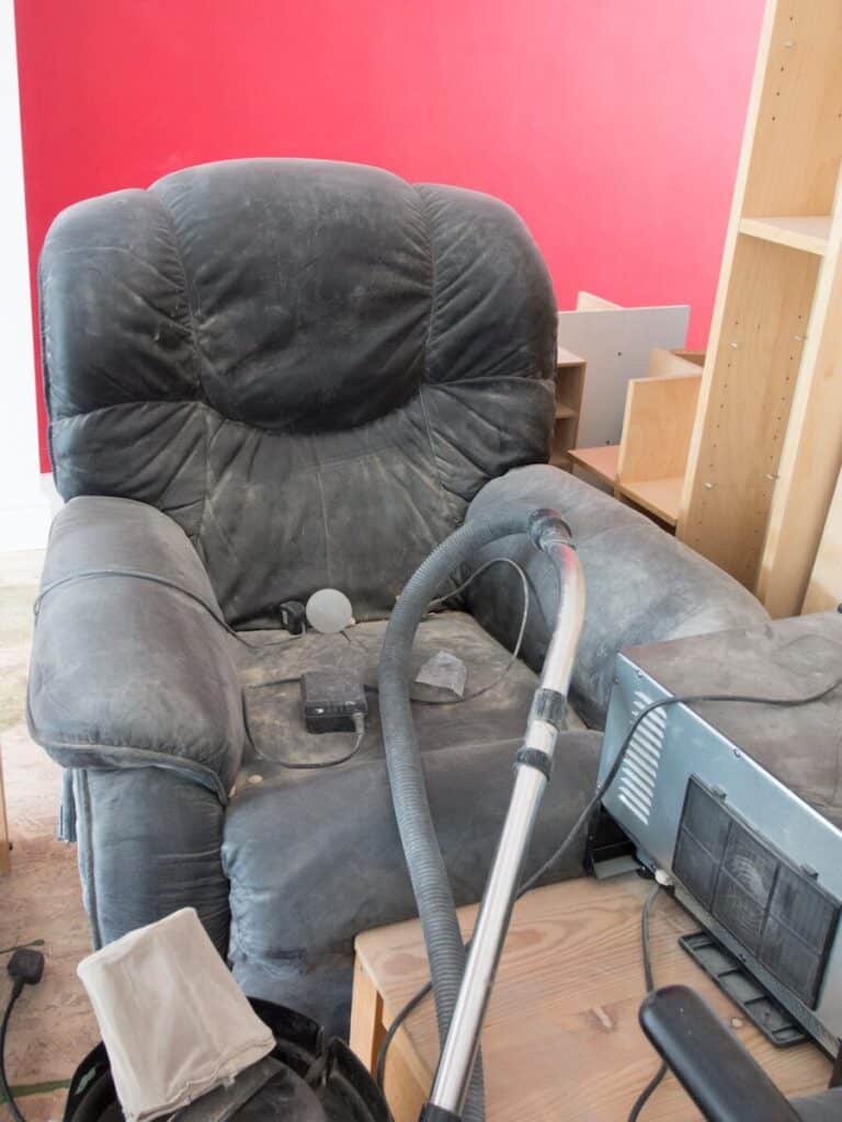 A living room with a couch and a vacuum